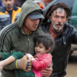 Two Men Carrying A Child After The 2023 Earthquake In Turkey And Syria