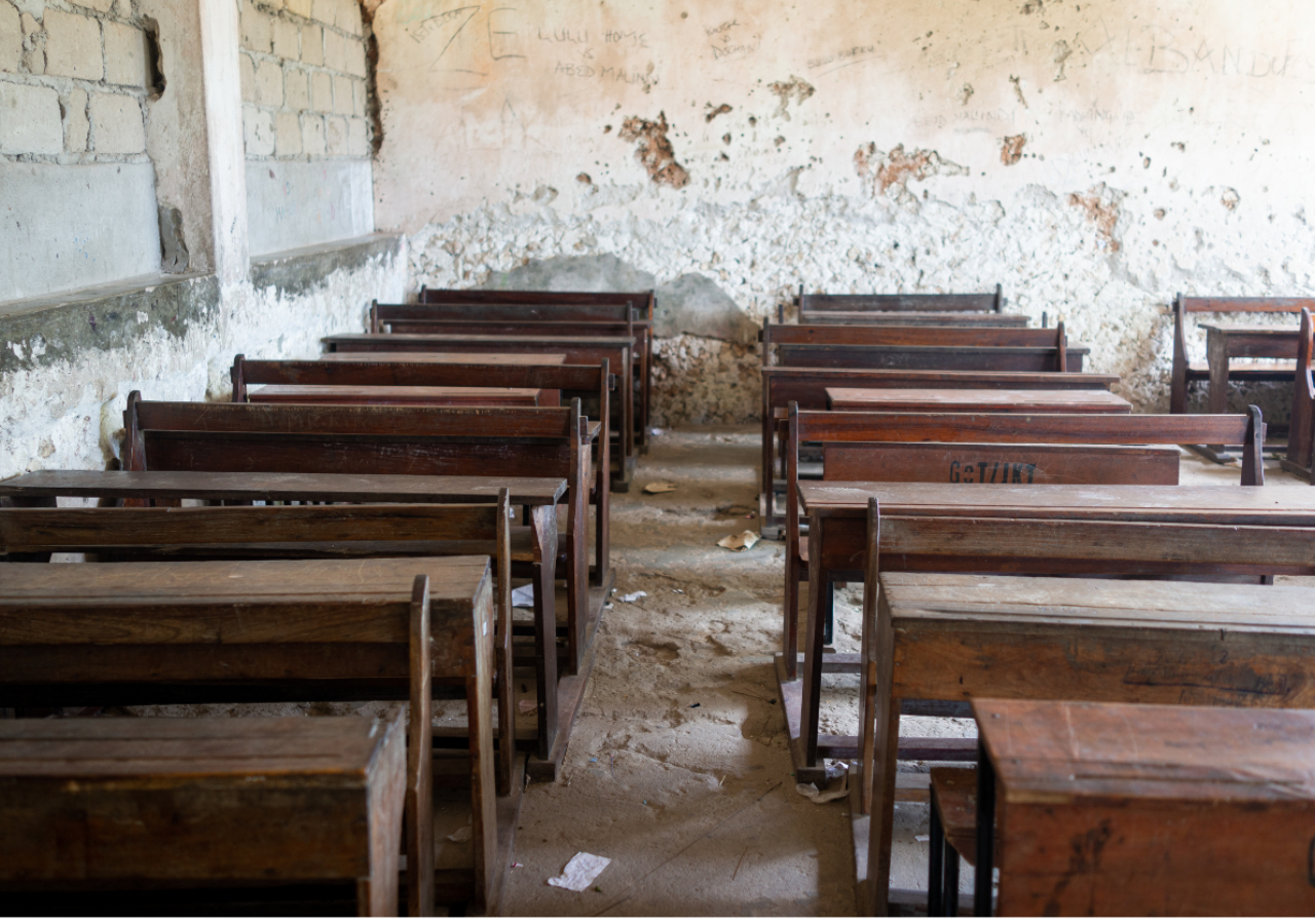 empty desks in a war damaged school in Syria